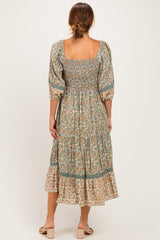 woman wearing a floral midi dress with a square neckline and puff sleeves, showing a gathered bodice and tiered skirt