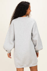 woman wearing a gray maternity sweatshirt dress with balloon sleeves, facing away from the camera