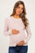 woman wearing a pink and white striped maternity long sleeve top and holding her baby bump