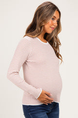 woman wearing a striped long sleeve maternity top and holding her baby bump
