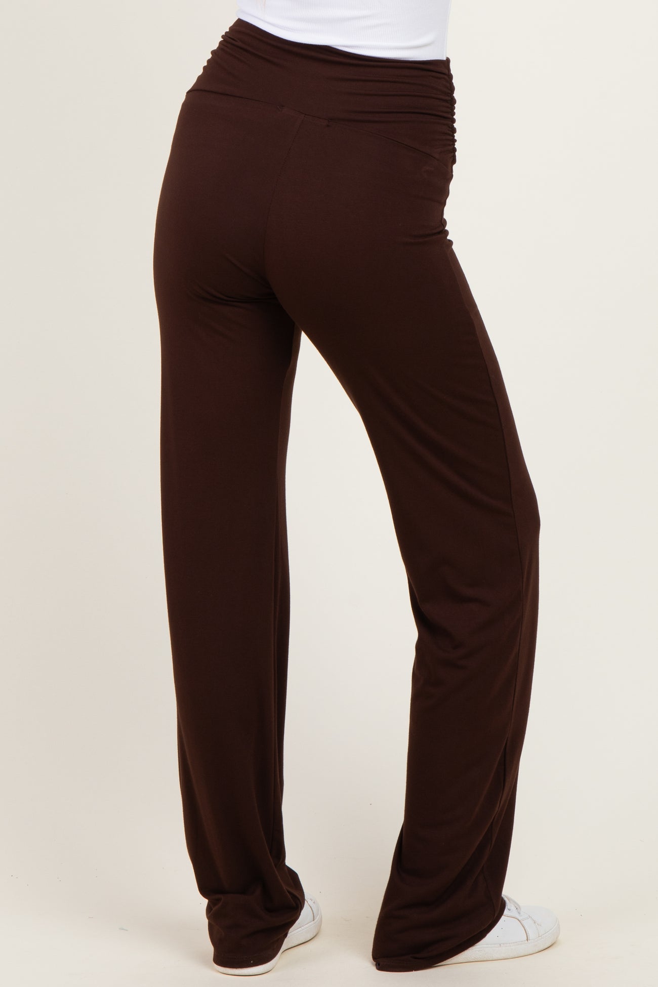 woman wearing brown wide leg pants with a ruched waistband, shown from the back