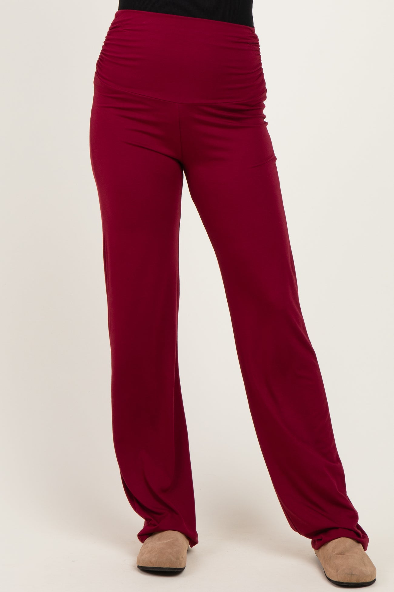 woman wearing maroon wide-leg pants with a high waistband and ruching details