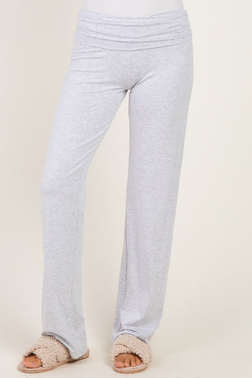woman wearing light gray wide-leg lounge pants with a fold-over waistband and slip-on fluffy slippers