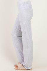 woman wearing light grey lounge pants with a wide waistband and loose fit, paired with cozy slippers
