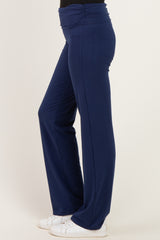 woman wearing navy blue wide-leg pants with a ruched waistband and white sneakers