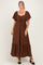 woman wearing a brown maxi dress with short puff sleeves and drawstring detail at the neckline