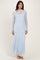 woman wearing a light blue long sleeve lace maxi dress with a fitted silhouette and high neckline