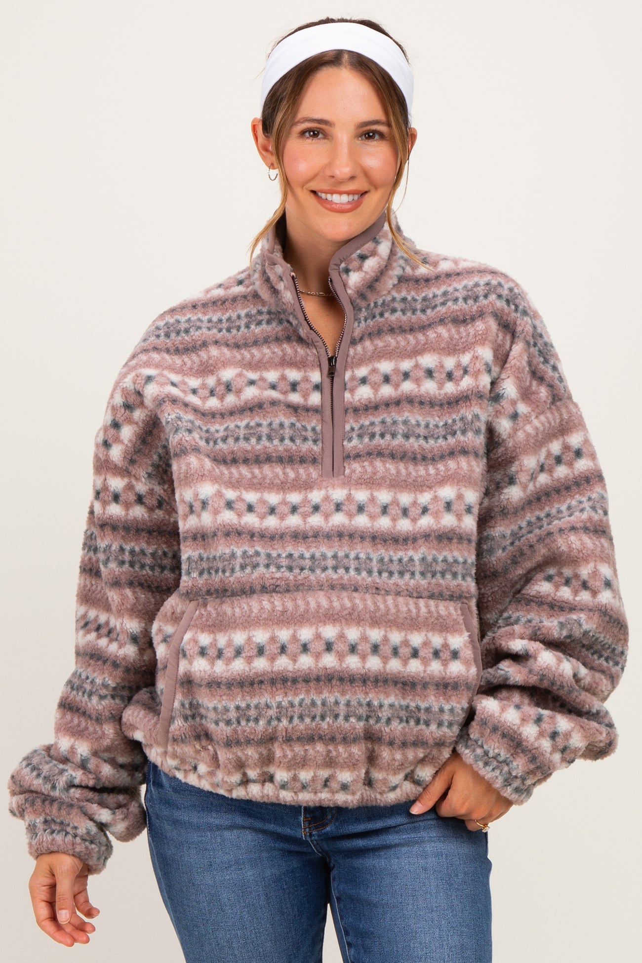 woman wearing a pink and gray patterned fleece pullover maternity wear with a half zip and relaxed fit