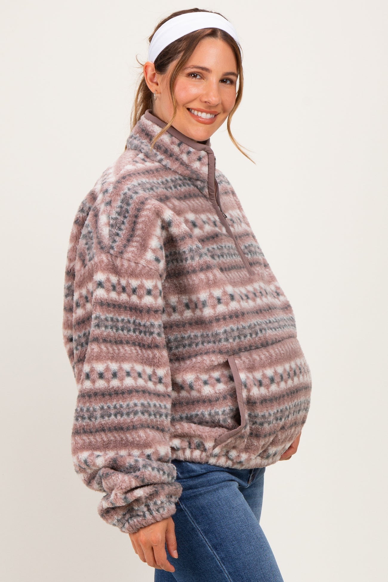 woman wearing a cozy patterned fleece maternity pullover and showing her baby bump