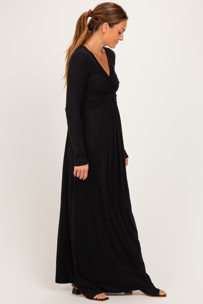 woman wearing a black long sleeve maxi dress with a twisted front detail