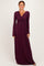 woman wearing a burgundy long sleeve maxi dress with a twisted front detailing and a flowing silhouette