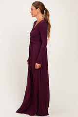woman wearing a long sleeve purple maxi dress with a twist detail at the waist