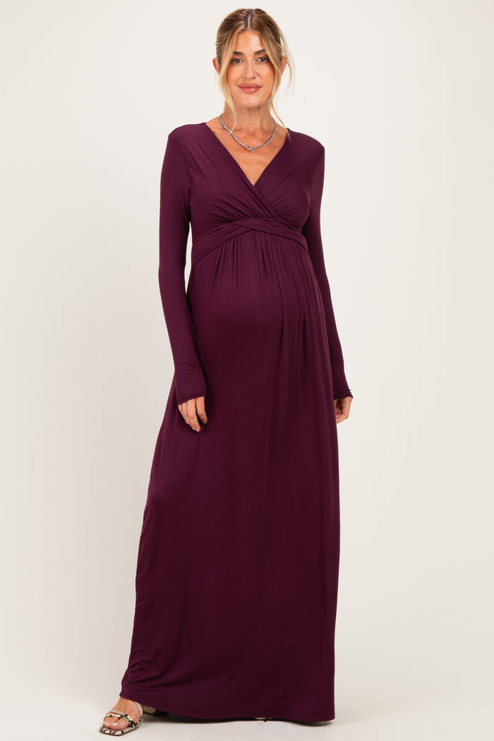 woman wearing a dark purple long sleeve maternity dress with a wrap-style bodice and baby bump visible