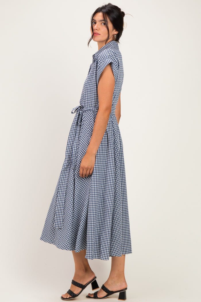 woman wearing a navy blue gingham midi dress with short sleeves and a tie waist detail