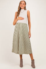 woman wearing a sleeveless grey mock neck maternity dress with green and white stripes and holding her baby bump