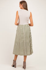woman wearing a sleeveless white top and a green and white striped maternity maxi skirt, showing a baby bump from behind