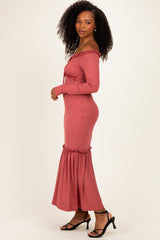 woman wearing a rust ribbed off-the-shoulder maxi dress with ruffled hem and long sleeves