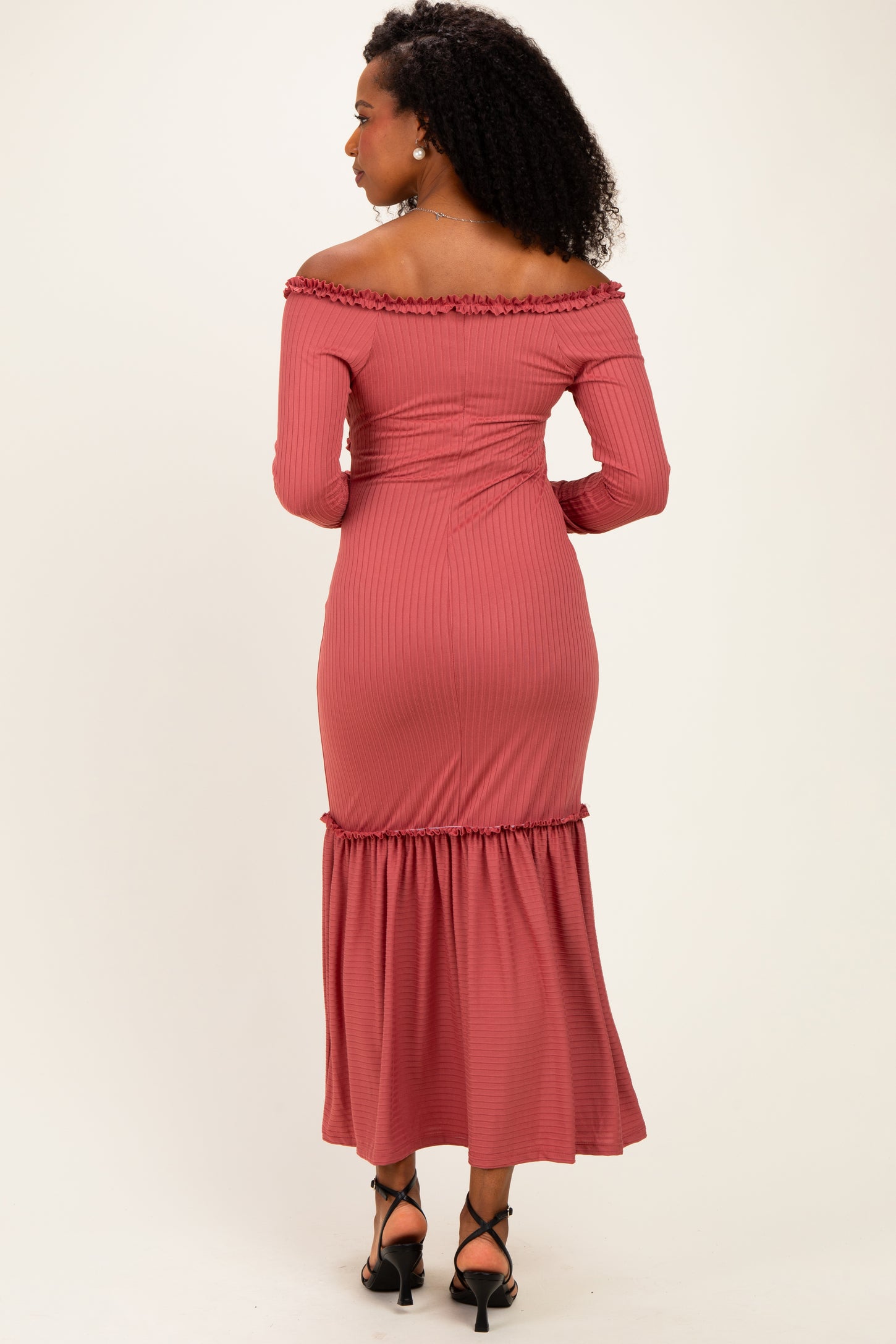 woman wearing a dusty rose off-the-shoulder ribbed maxi dress with a ruffled hem and fitted waist