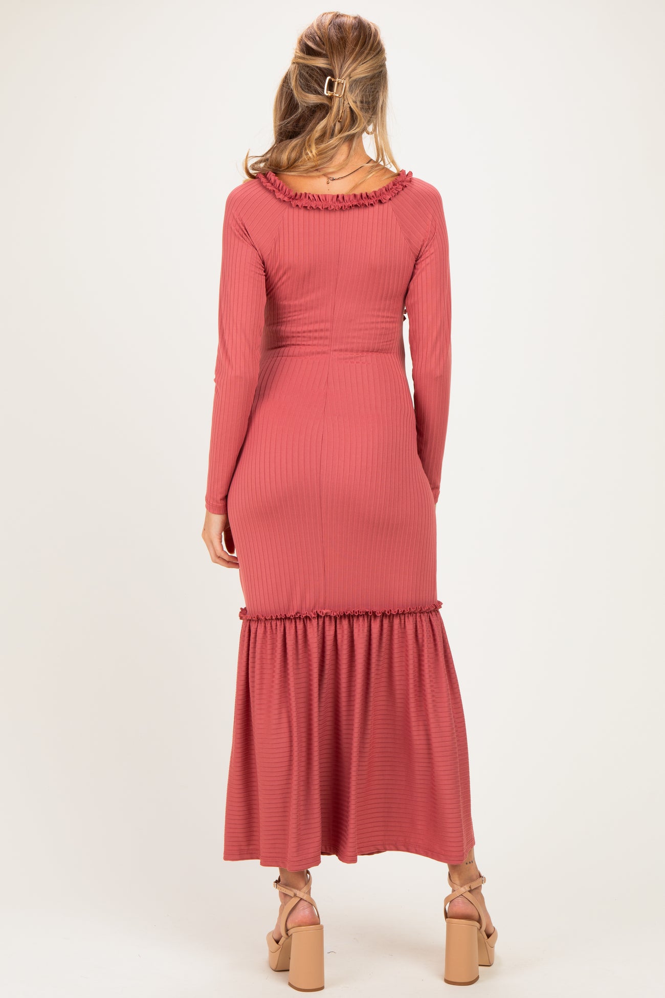 woman wearing a dusty rose maternity dress with ruffles and a flowy skirt, showcasing a baby bump from the back