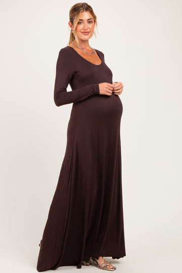woman wearing a dark brown long sleeve maternity dress and showing her baby bump
