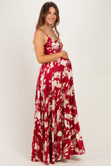 woman wearing a red and white floral maternity maxi dress and holding her baby bump