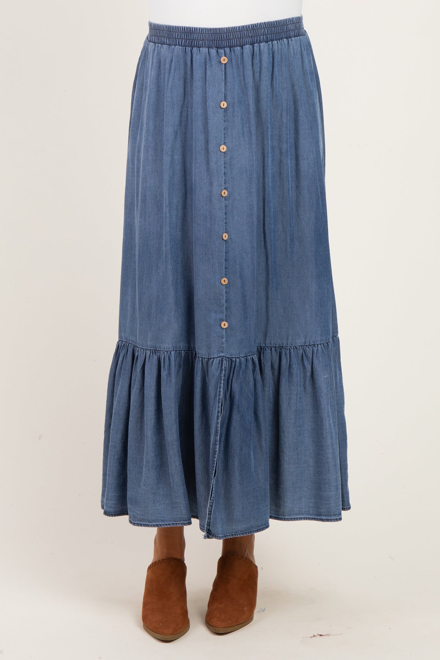 maternity wear denim maxi skirt with tiered ruffle hem and front buttons, paired with brown ankle booties