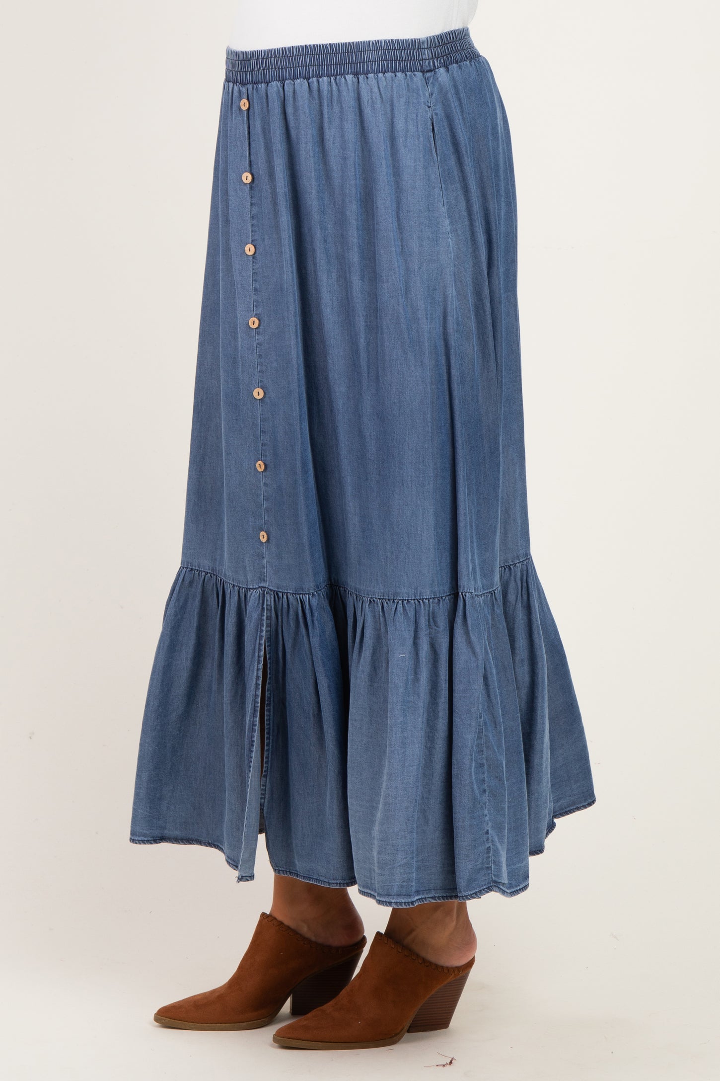 maternity wear denim maxi skirt with button detail and tiered ruffle hem, worn by a model with brown ankle boots