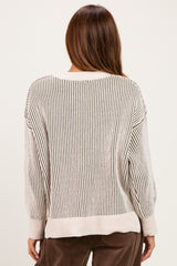 woman wearing a cream and beige striped oversized sweater, showing the back view