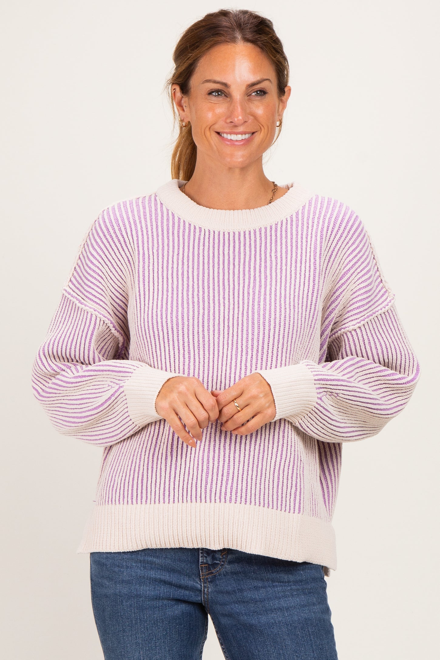 woman wearing a cream and lavender striped oversized sweater with balloon sleeves and a relaxed fit