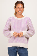 woman wearing a cream and lavender striped oversized sweater with balloon sleeves and a relaxed fit