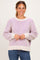 woman wearing a cream and lavender striped oversized sweater with balloon sleeves and a relaxed fit