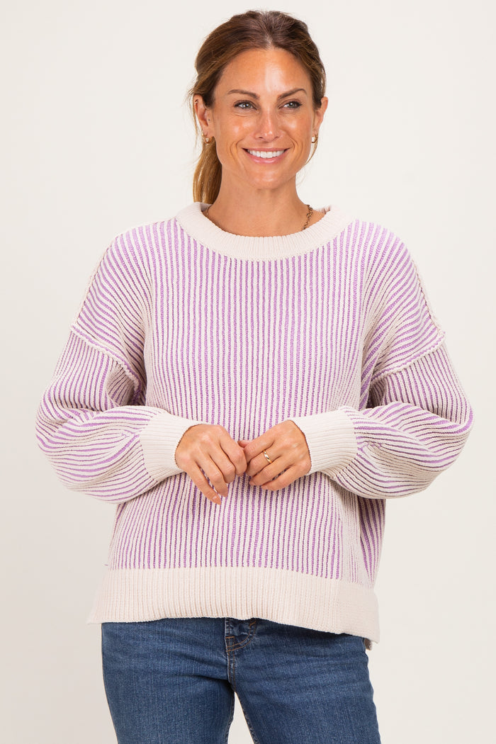 woman wearing a cream and lavender striped oversized sweater with balloon sleeves and a relaxed fit