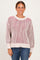 woman wearing a cream and red striped knit sweater with a relaxed fit and ribbed details, paired with blue jeans