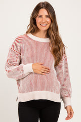 woman wearing a striped red and cream maternity sweater and holding her baby bump
