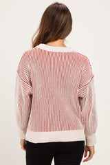woman wearing a striped red and white oversized maternity sweater with balloon sleeves, seen from the back