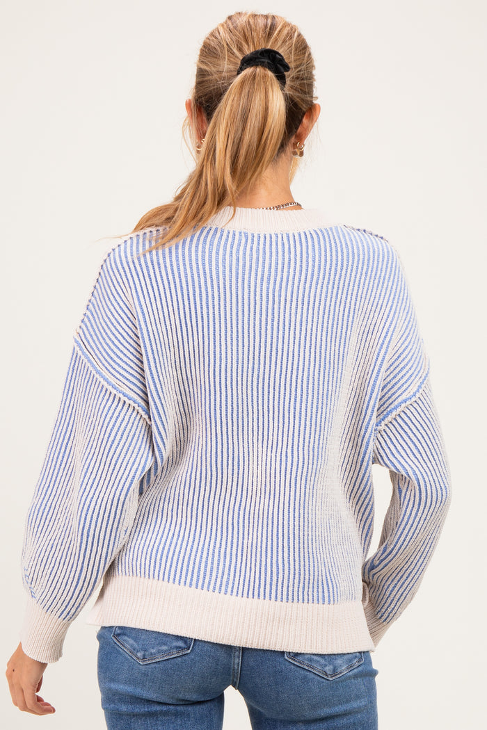 woman wearing a striped maternity sweater in light blue and cream, showing the back view with relaxed fit and dropped shoulders