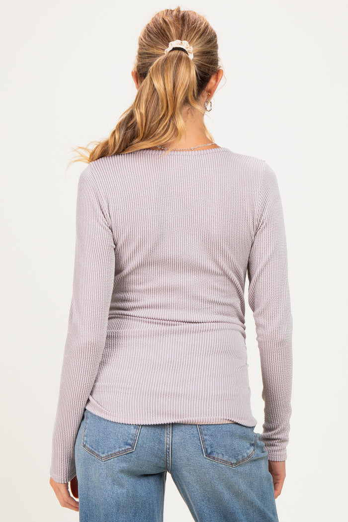 woman wearing a light purple ribbed long sleeve maternity top, showing a fitted style on the back