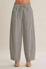 woman wearing black and white striped wide-leg pants with an elastic waistband and side pockets