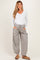 woman wearing a white long sleeve v-neck maternity top and gray striped wide-leg maternity pants with pockets