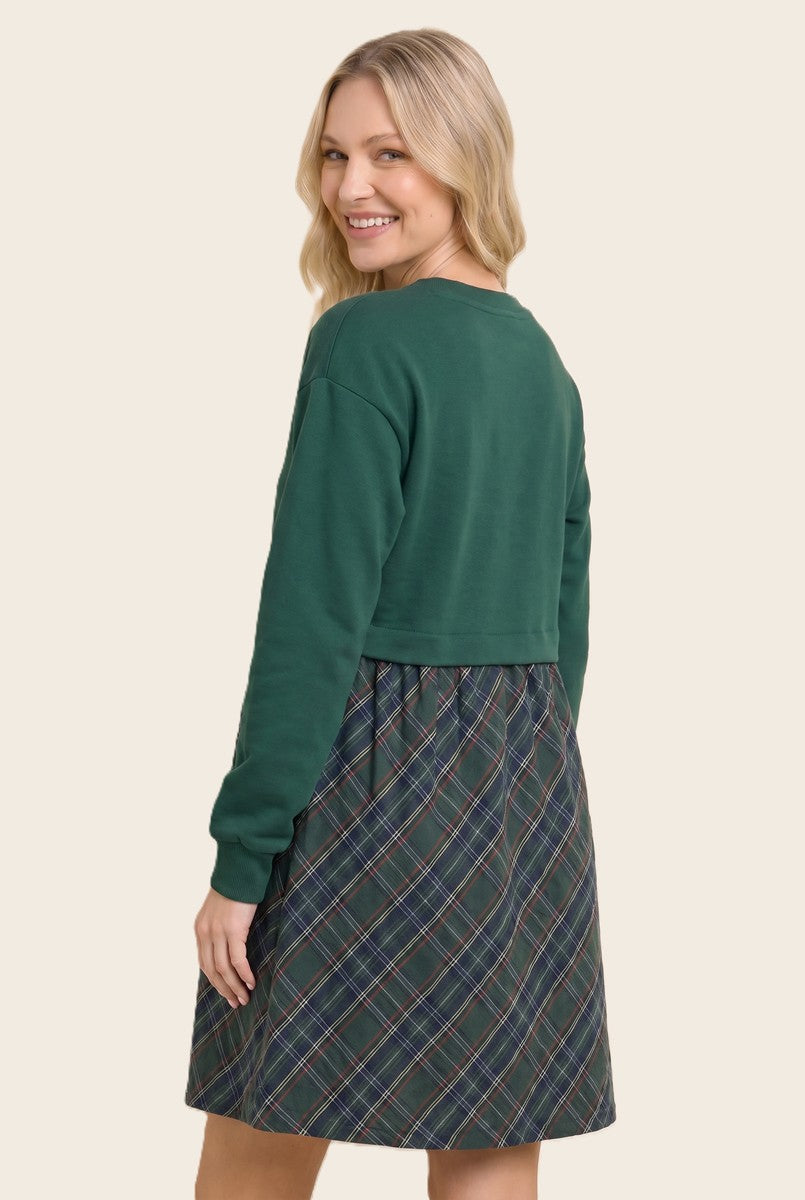 woman wearing a green cropped sweatshirt with a plaid skater dress in green and navy blue.