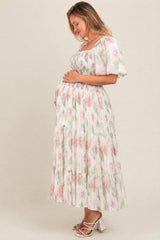 woman wearing a floral print maternity maxi dress with short sleeves and a baby bump visible