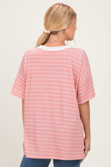 woman wearing a pink and white striped oversized t-shirt with short sleeves and a relaxed fit