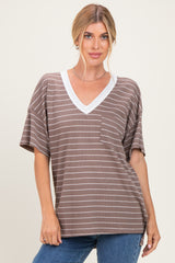 woman wearing a brown striped v-neck top with a white collar and pocket, styled with blue jeans