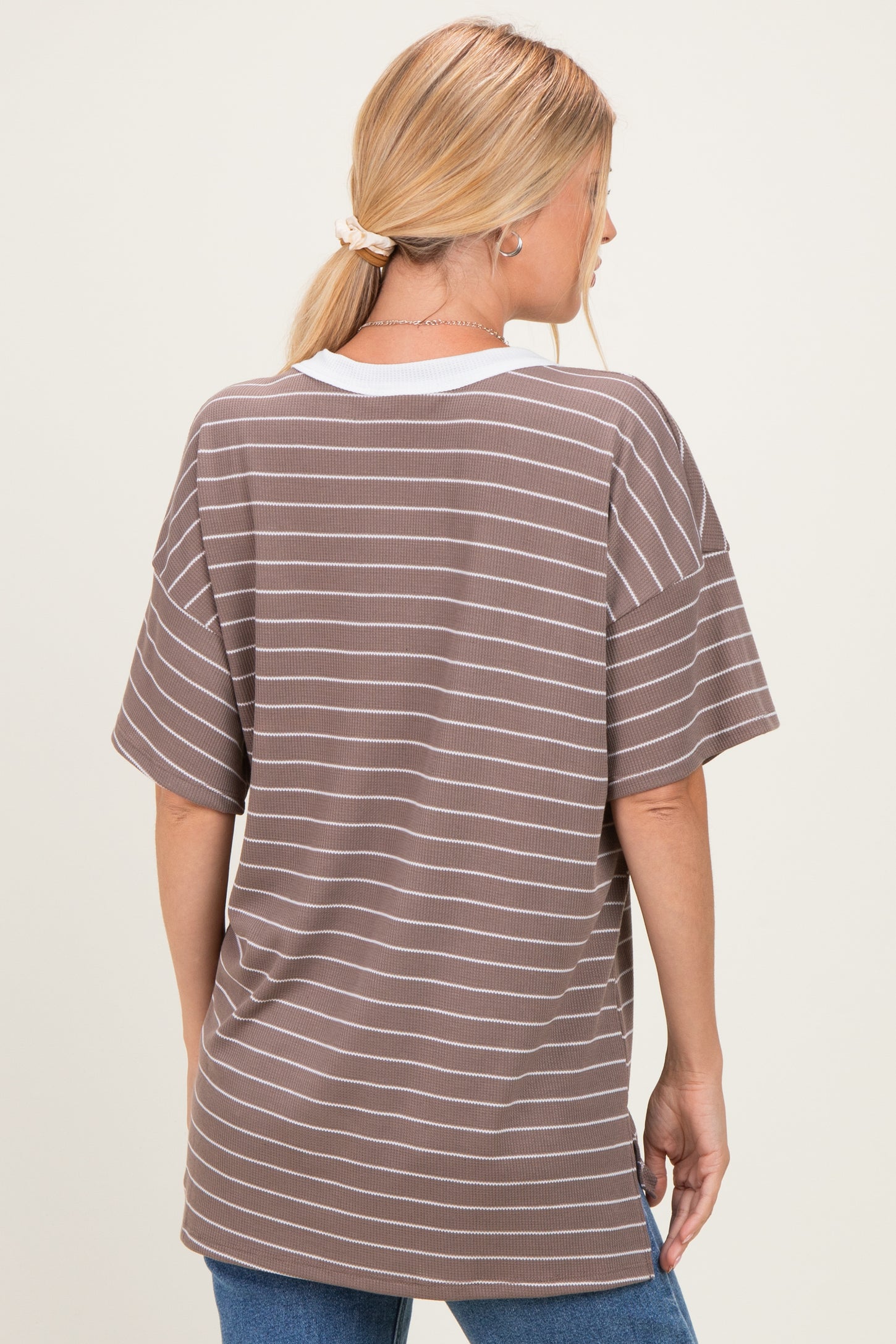 woman wearing a brown and white striped oversized t-shirt from the back, styled with loose sleeves