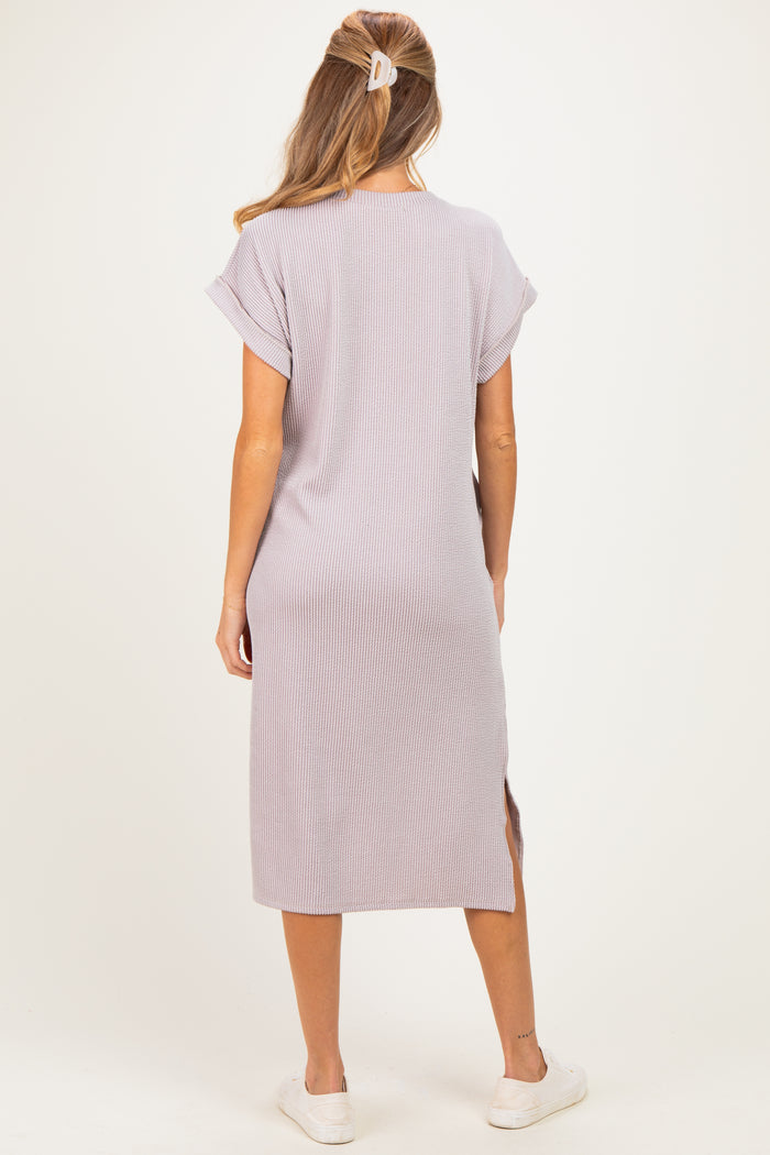 woman wearing a light purple maternity dress with short sleeves and side slits, showing a relaxed fit and casual style