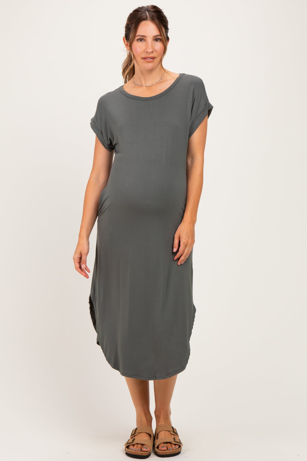 woman wearing a gray short sleeve maternity dress with a relaxed fit and side slits, showing her baby bump