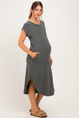 woman wearing a dark gray short sleeve maternity dress with pockets and a baby bump visible