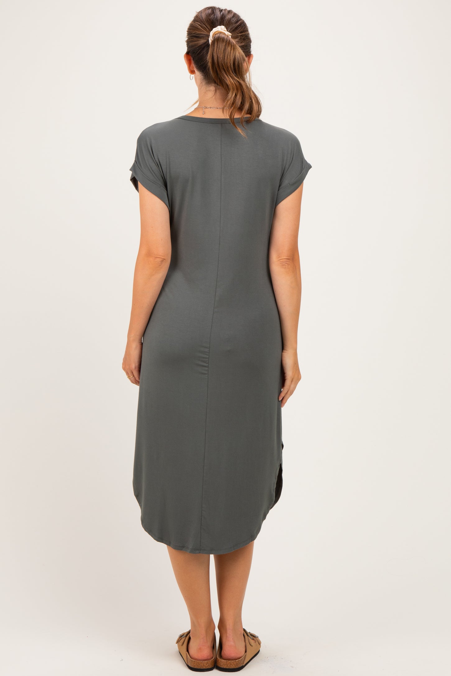 woman wearing a grey maternity dress with short sleeves and a knee-length cut, shown from the back