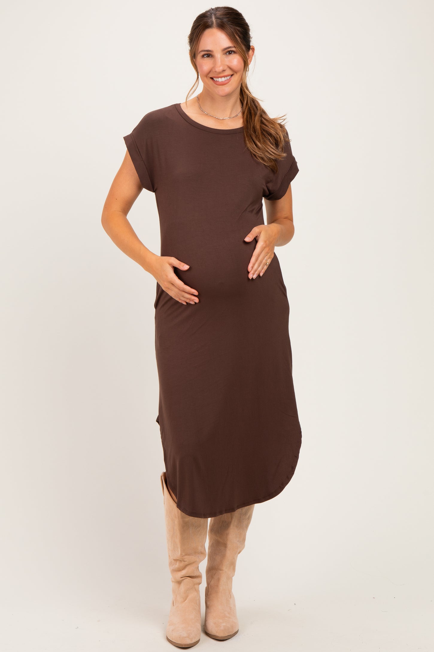 woman wearing a brown short sleeve maternity dress and holding her baby bump