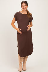 woman wearing a brown short sleeve maternity dress and holding her baby bump